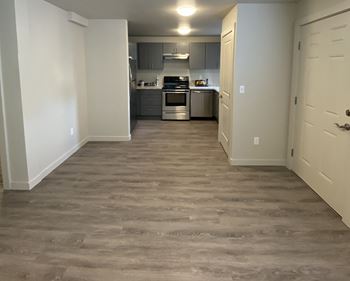 a view of a kitchen and a hallway with wood flooring  at The Lakes Apartments, Washington